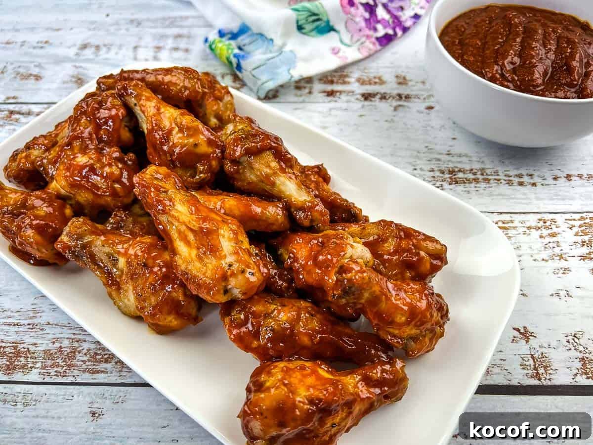 39 Outdoor Grilling Dinners That Make You Ditch the Oven Tonight 16 Ninja Woodfire Grill Wings with Jack Daniel's BBQ Sauce on a white plate.