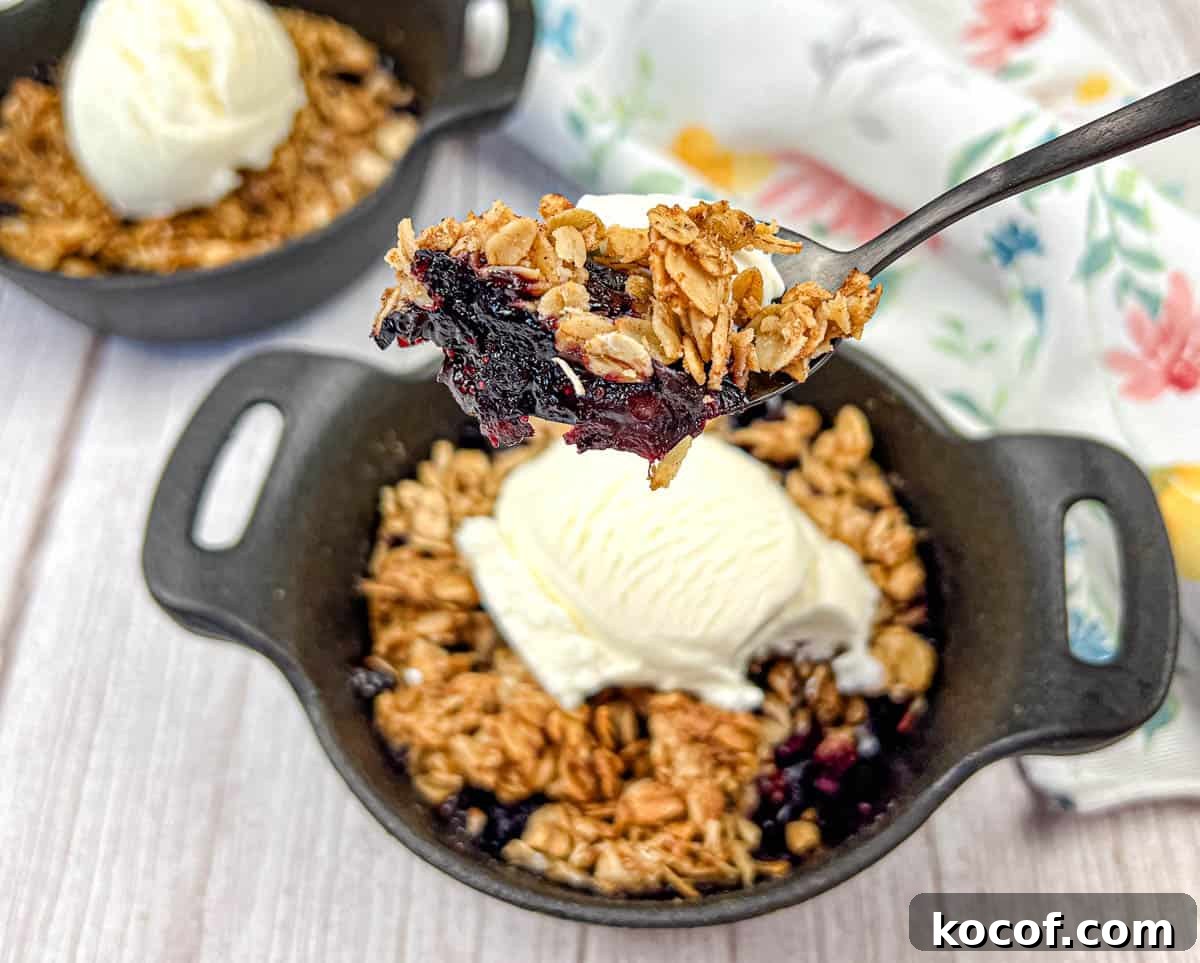 39 Outdoor Grilling Dinners That Make You Ditch the Oven Tonight 19 A spoon lifts a portion of Smoked Berry Crisp from a bowl.