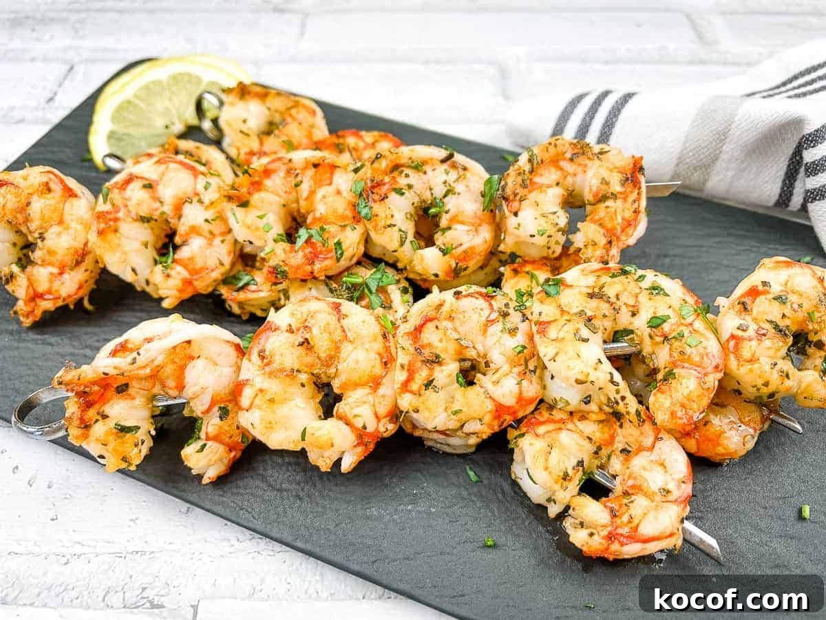 39 Outdoor Grilling Dinners That Make You Ditch the Oven Tonight 21 Mediterranean Grilled Shrimps on a white plate with lemon wedges.