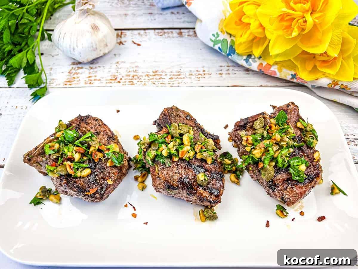 39 Outdoor Grilling Dinners That Make You Ditch the Oven Tonight 22 Three Grill Mediterranean Lamb Chops topped with gremolata on a white plate.