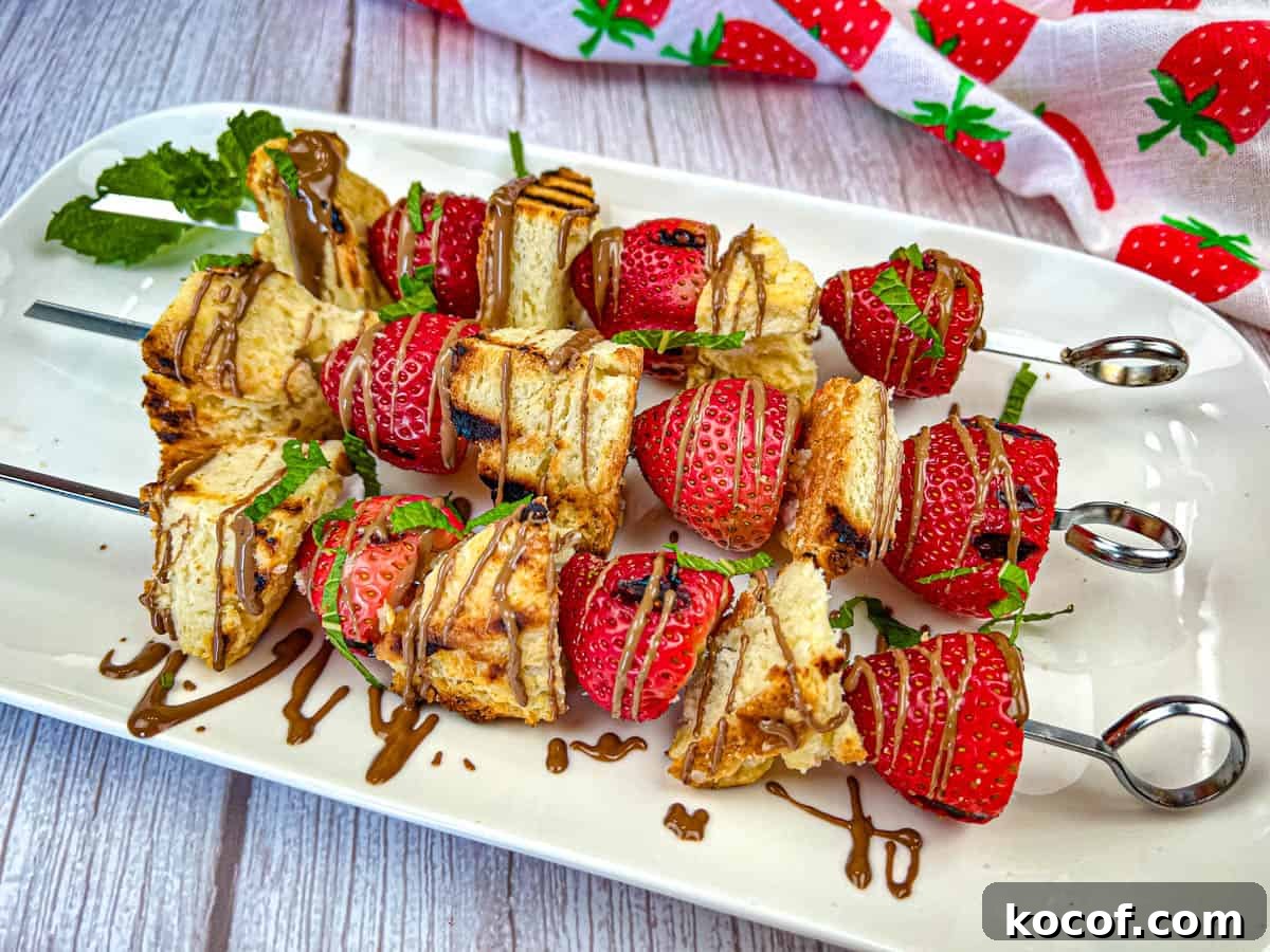 39 Outdoor Grilling Dinners That Make You Ditch the Oven Tonight 27 Three pieces of Grilled Strawberry Shortcake Skewers on a white plate.