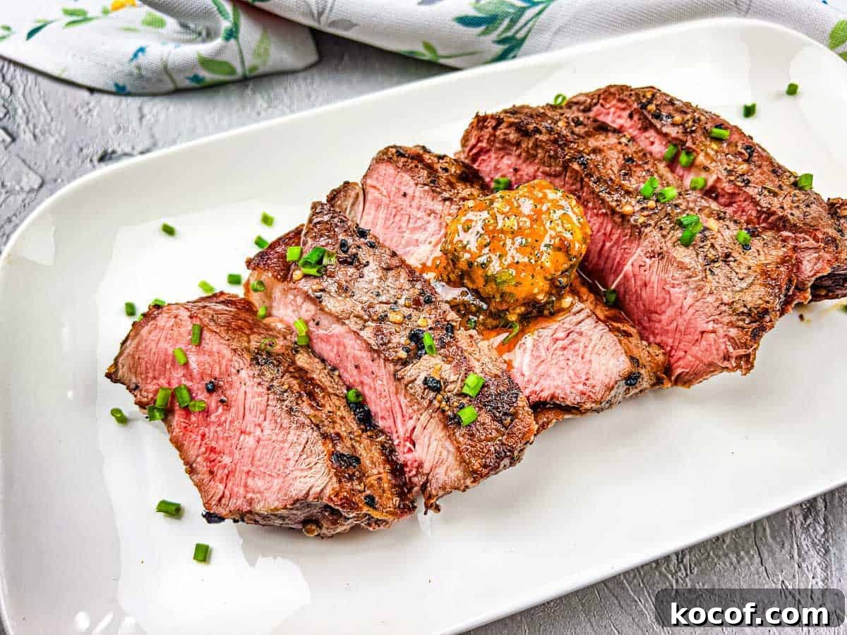 39 Outdoor Grilling Dinners That Make You Ditch the Oven Tonight 36 A grilled steak with cowboy butter on a white plate.