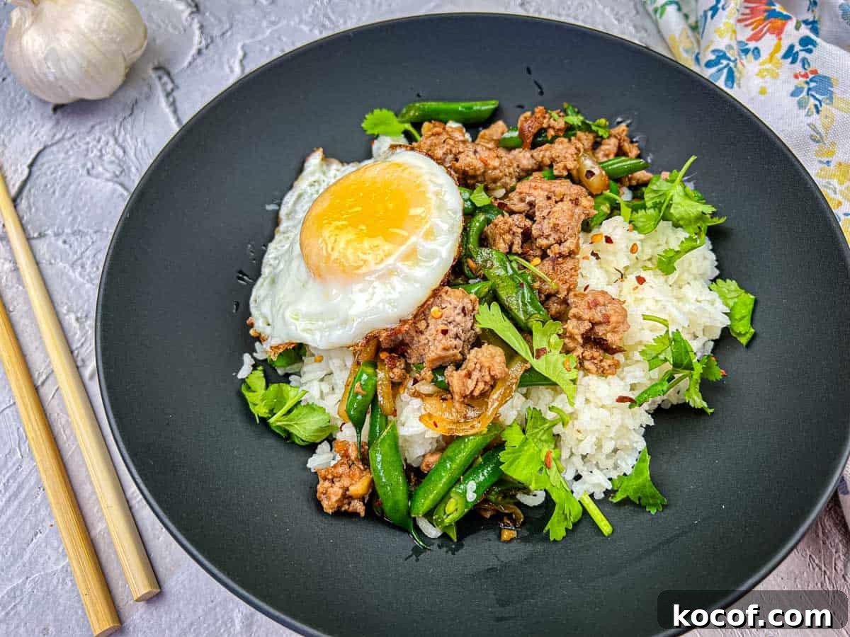 39 Outdoor Grilling Dinners That Make You Ditch the Oven Tonight 41 A plate of Thai pork & Green beans with rice, topped with a fried egg, served with chopsticks on the side.