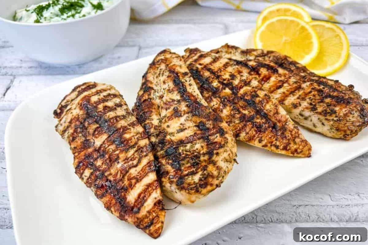 39 Outdoor Grilling Dinners That Make You Ditch the Oven Tonight 8 Grilled Greek Chicken on a white plate with lemon slices.