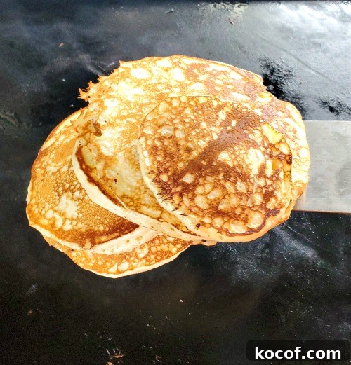 Blackstone Griddle Pancakes cooking on Blackstone with spatula under it 
