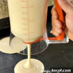 Blacckstone Pancake dispensor pouring batter onto blackstone griddle