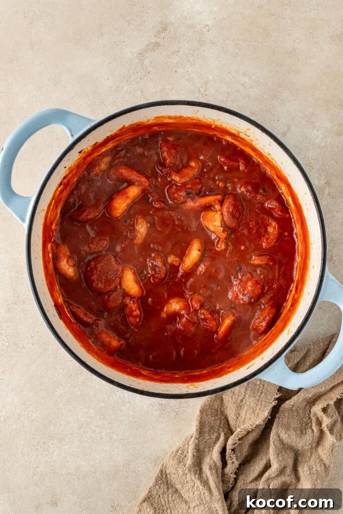 The tomato sauce and chorizo added into the pot.