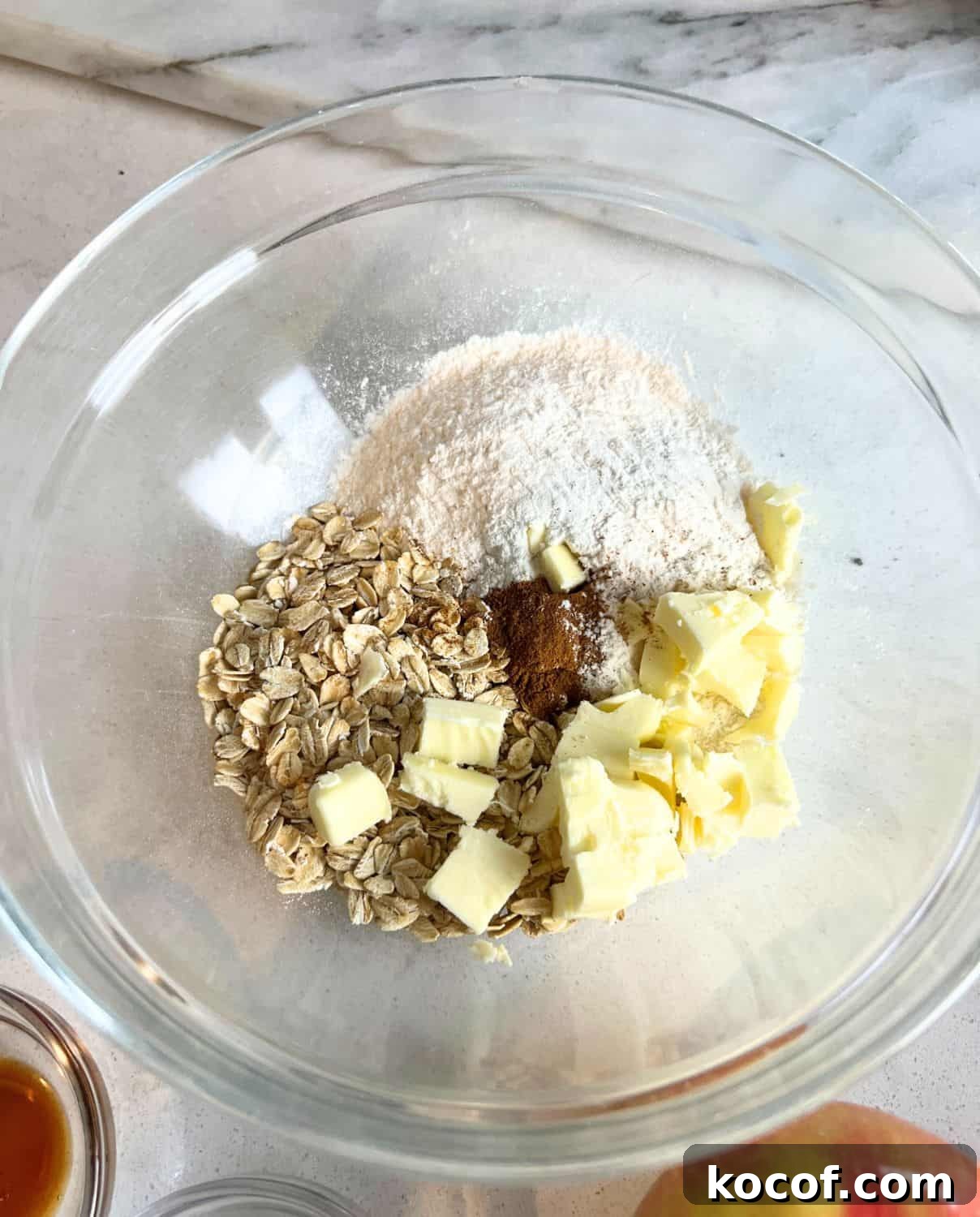 Dry ingredients in a glass bowl for apple crisp. 