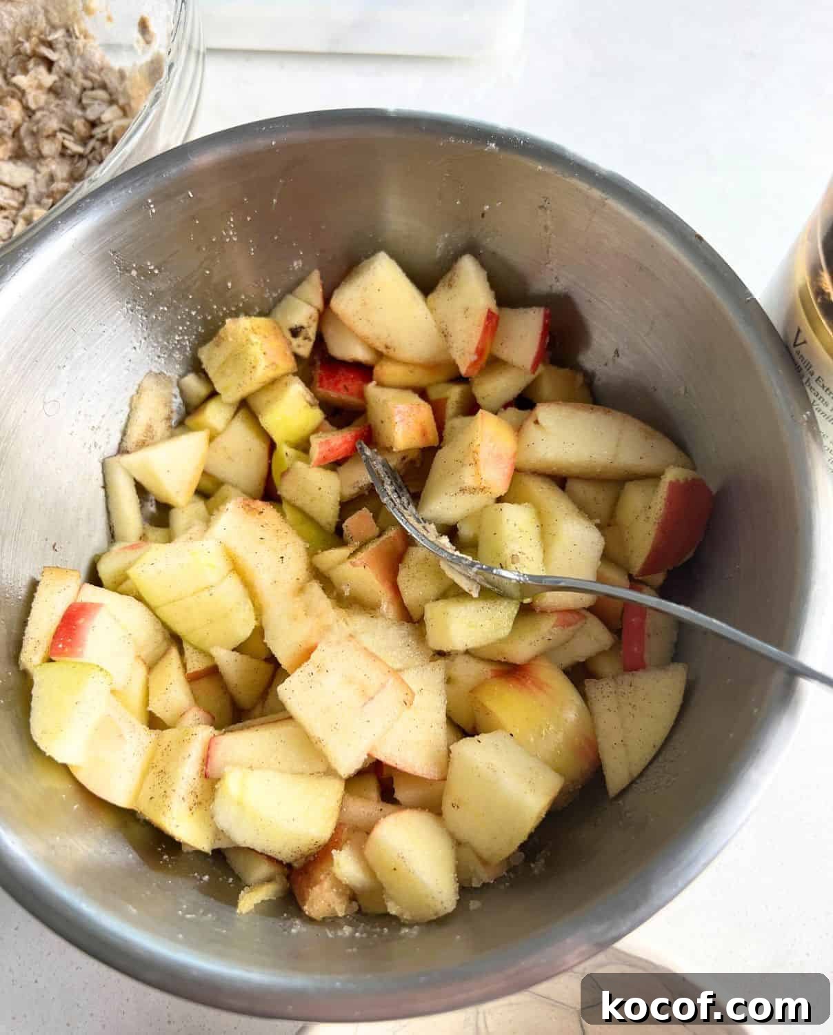 Apples in a bowl mixed with sugar and spices. 