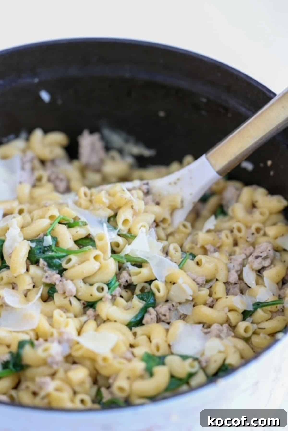 One-Pot Ground Turkey Pasta Skillet Recipe for Quick Dinners 2 Ground Turkey and Pasta dish in a white Staub Dutch oven with a white and gold serving spoon.