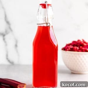 A glass flip lock bottle with a rhubarb simple syrup and fresh rhubarb.