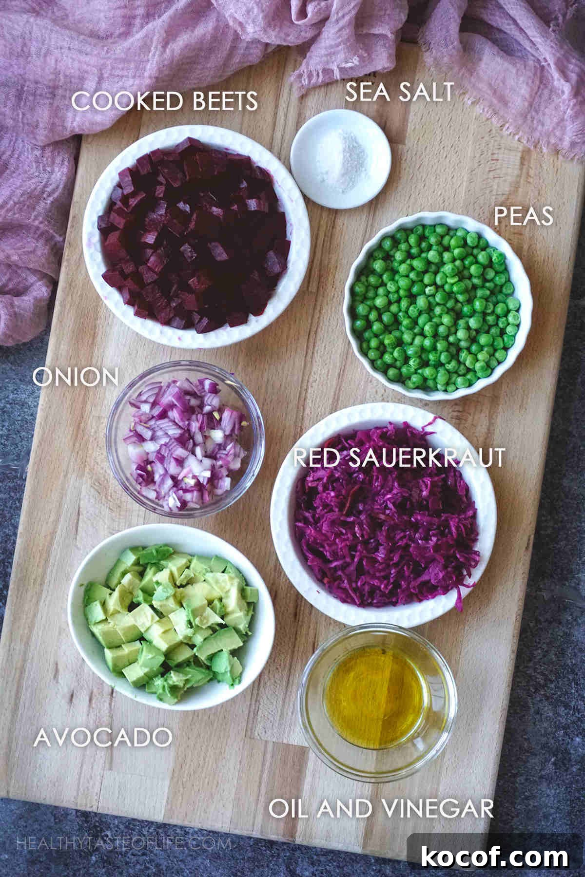 Russian Vinaigrette Salad with Beets and Sauerkraut 4 Ingredients for Russian Vinaigrette displayed on a board, measured: roasted beets, peas, sauerkraut, onion, avocado, salt, vinegar.
