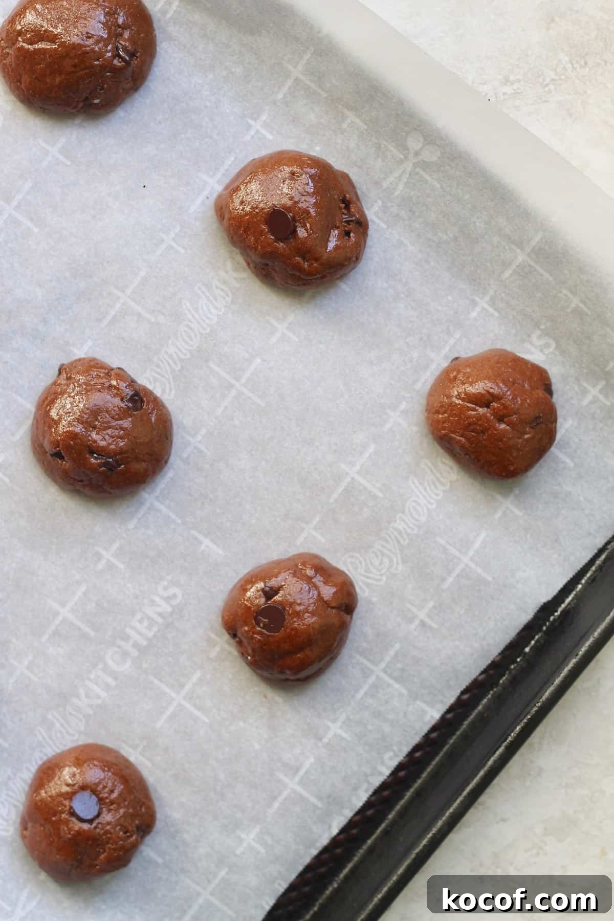 balls of chocolate cookie dough on lined baking sheet