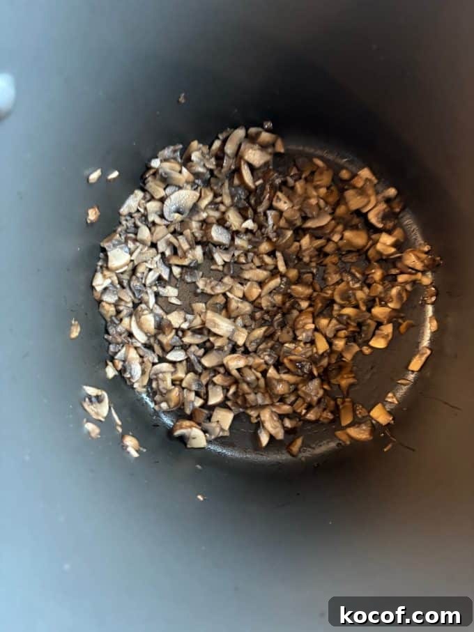 overhead image of nonstick pot cooking diced mushrooms