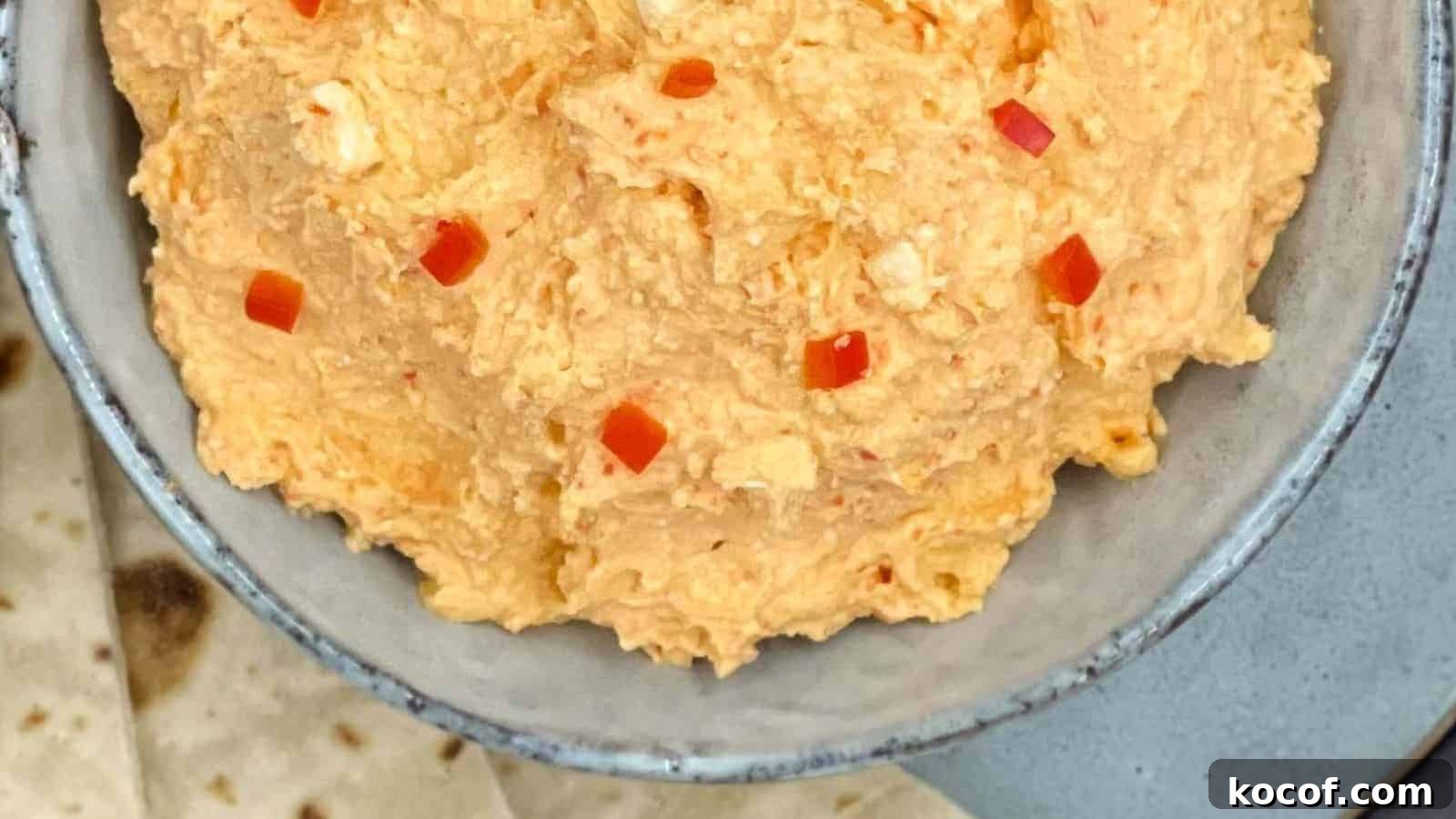 Spicy Greek feta dip in a bowl with pita bread by the side.