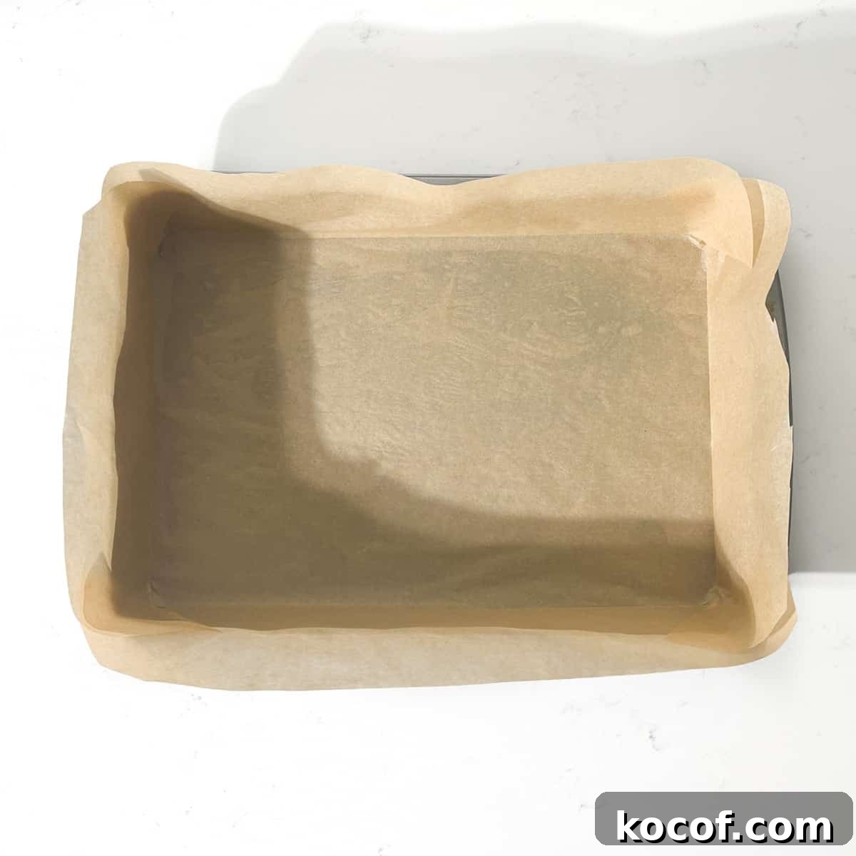A baking tin neatly lined with baking paper.