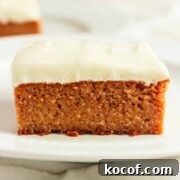 A square of pumpkin spice cake with creamy cheese frosting.