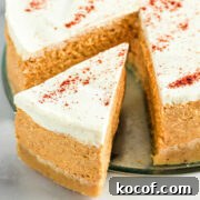 A slice of keto pumpkin cheesecake coming out of a whole cheesecake.