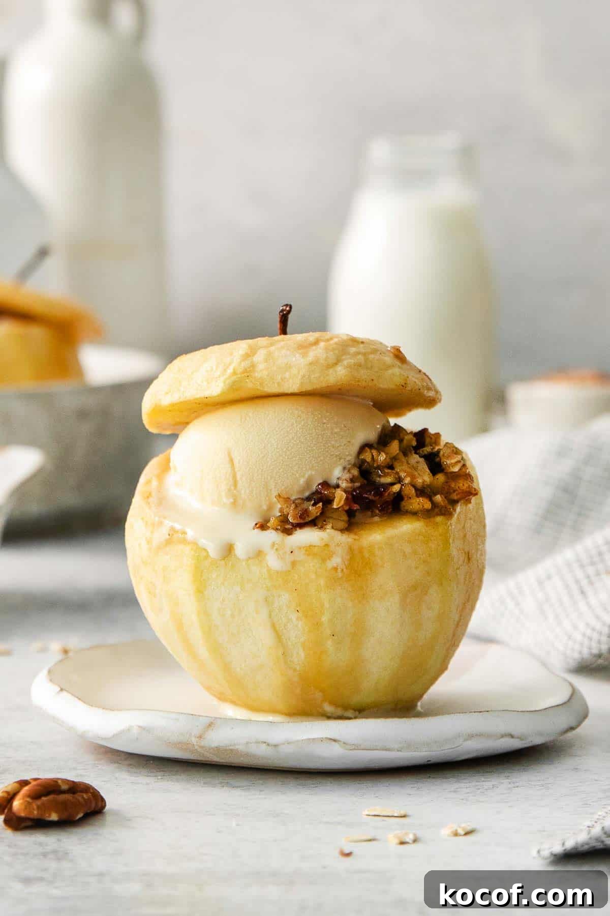 A baked apple with filling and a scoop of ice cream on a plate