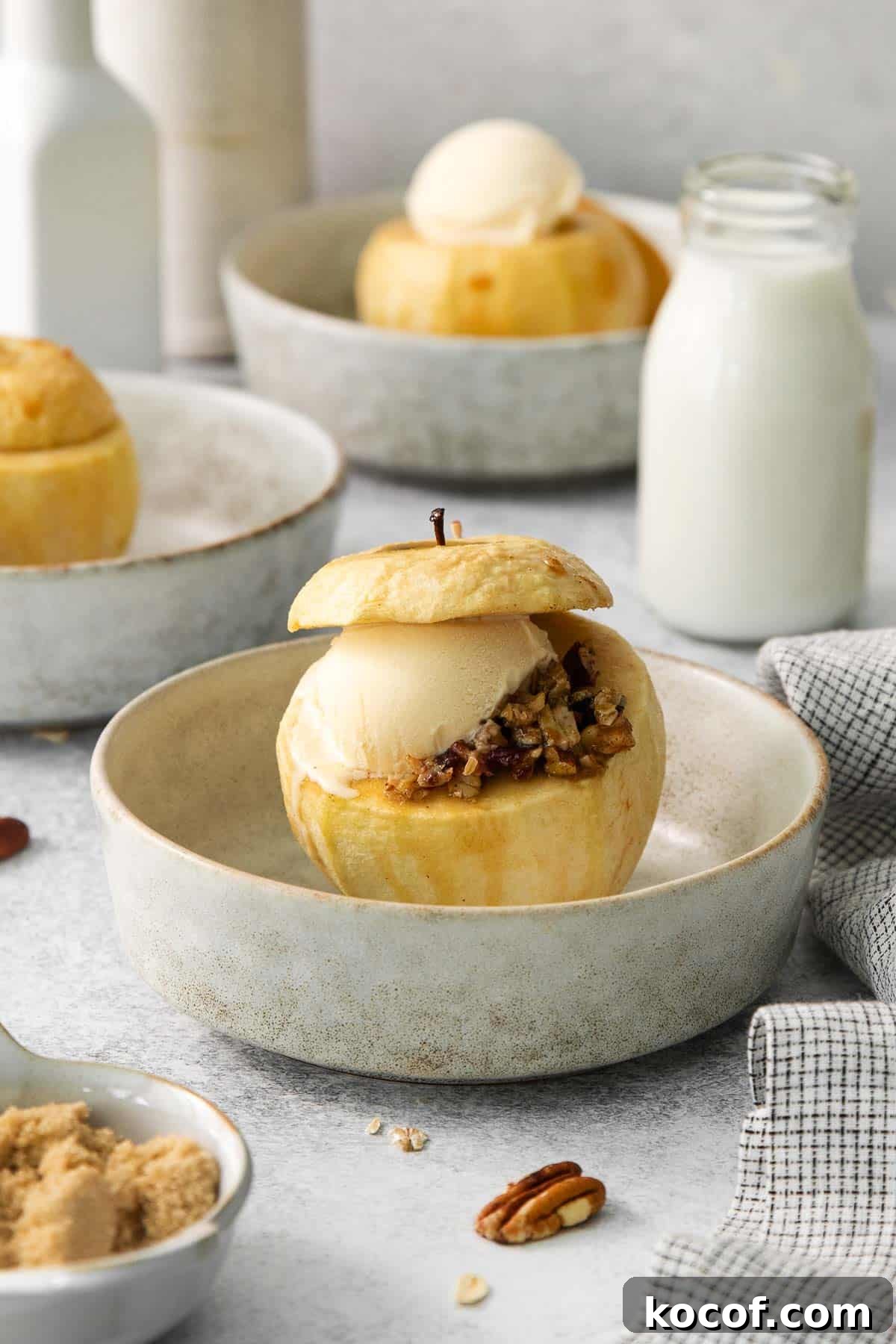A baked apple with filling and a scoop of ice cream on a plate