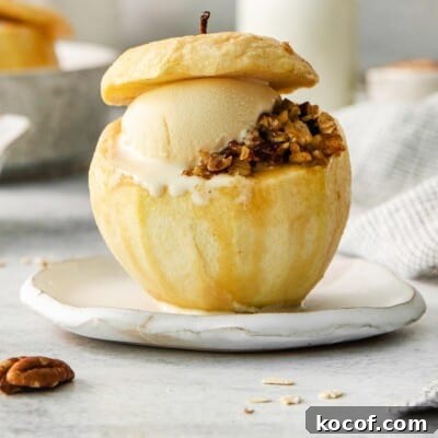A baked apple with filling and a scoop of ice cream on a plate