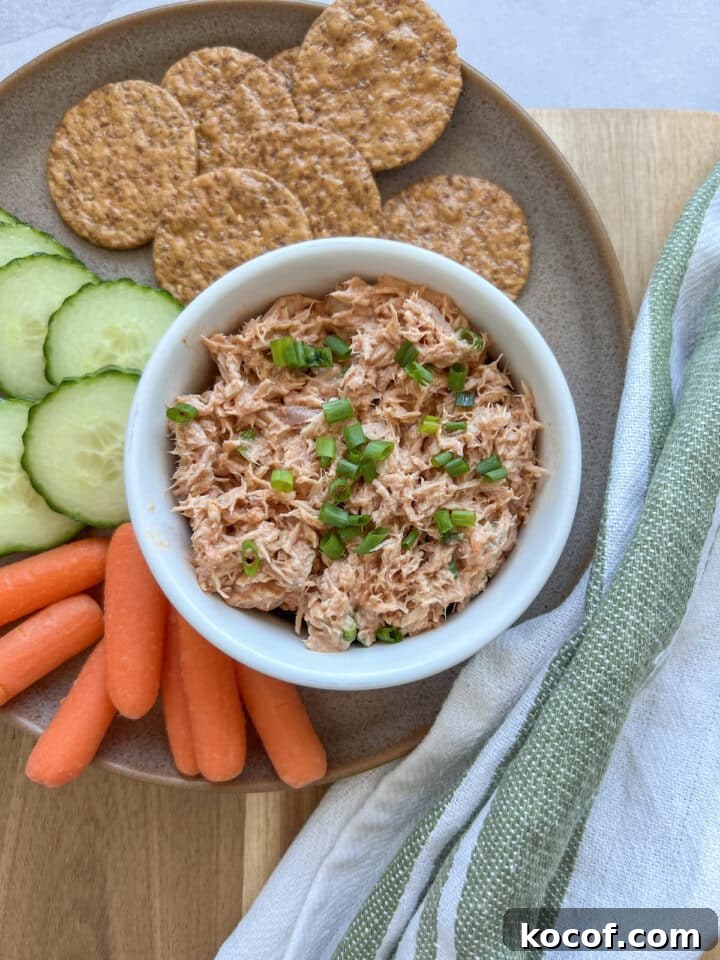 Buffalo tuna dip served on a plate with crackers, cucumber slices, and baby carrots.