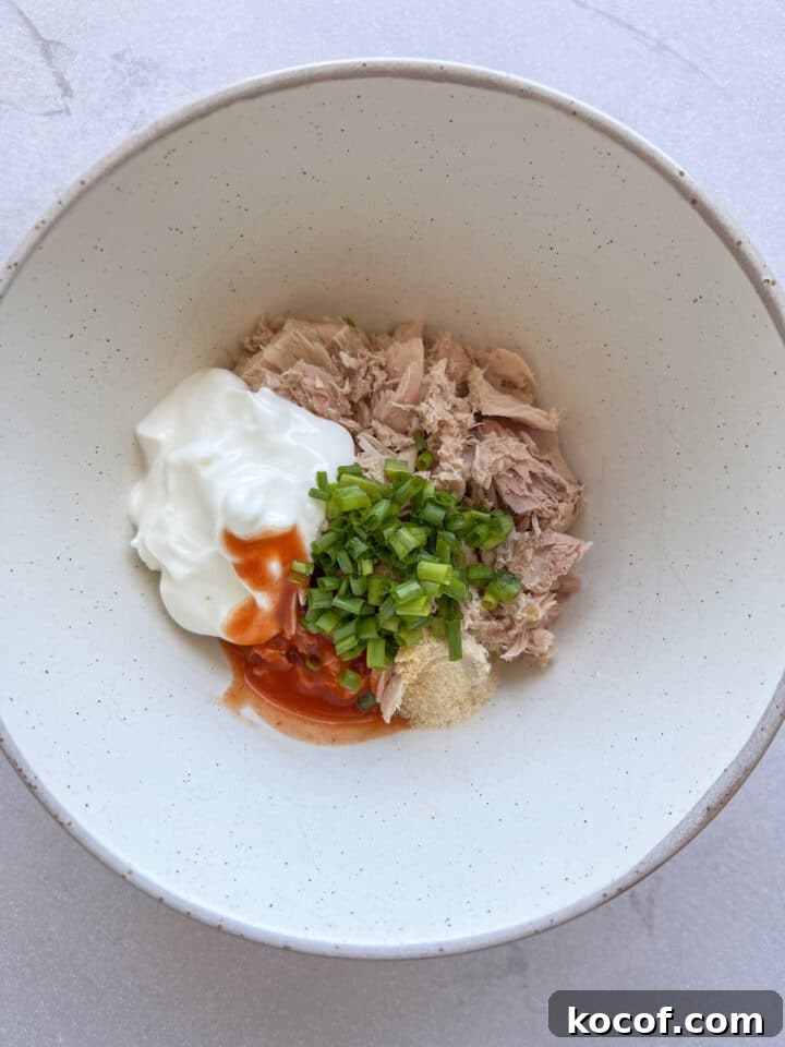 Ingredients for buffalo tuna dip in a white bowl, unmixed