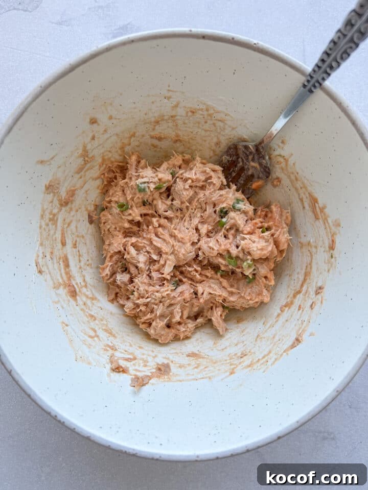 Buffalo tuna dip mixed in a white bowl with a spoon
