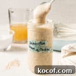 Gluten-free Cream of Chicken Condensed Soup in a mason jar dripping from a spoon.
