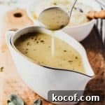 Gluten-free gravy in a gravy boat dripping from a spoon above.