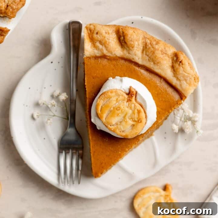 A slice of gluten free pumpkin pie on a small pumpkin shaped plate.