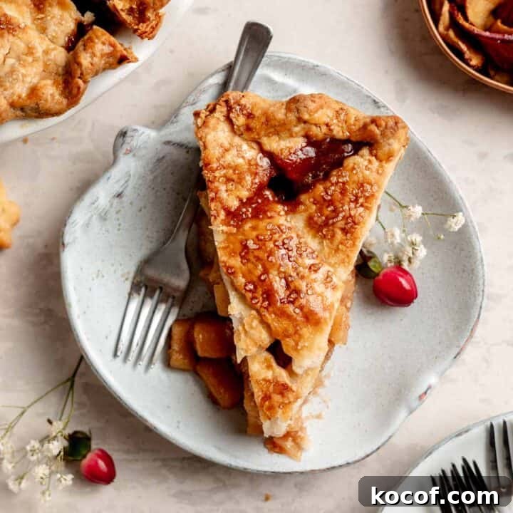 A slice of gluten free apple pie with lettuce top on small apple shaped plate.