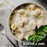 A bowl of gluten-free macaroni and cheese garnished with fresh parsley.