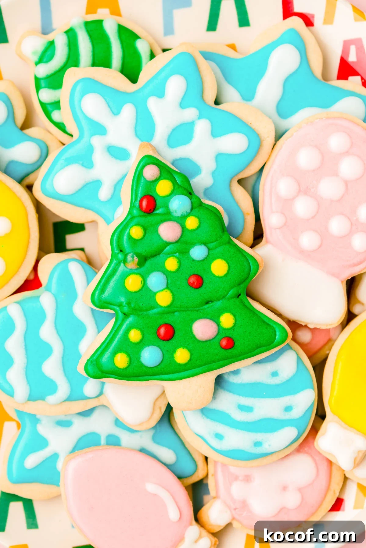 Royal iced sugar cookies for Christmas piled on a plate.