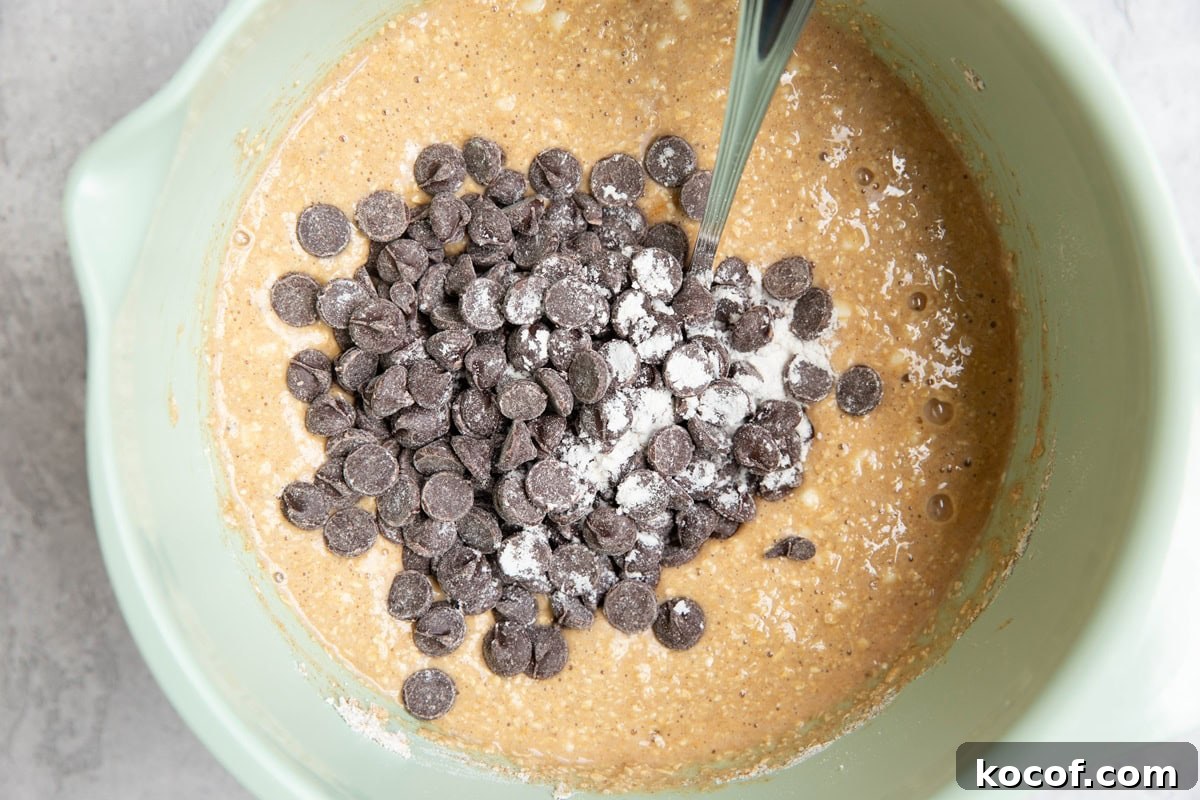 Oatmeal quick bread batter in a mixing bowl with chocolate chips sprinkled on top.